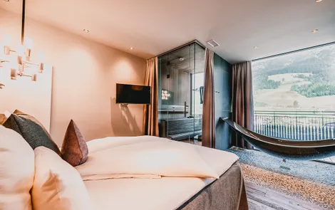 Luxury Spa Penthouse Modern hotel room with double bed, hammock lounger, sauna and mountain view